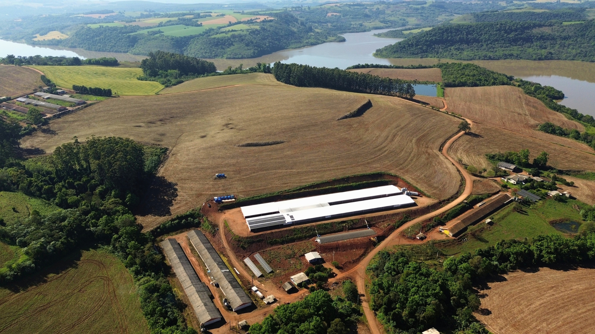 Vista aérea de granja próxima a áreas de cultivo e reservatórios